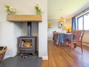 a living room with a stove and a dining room with a table at Three Jays in Emsworth