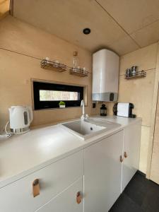 uma cozinha com um lavatório branco e uma janela em Domek na drzewie Ceprowo em Szczyrk