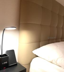 卡瓦拉的住宿－Apartments@Tsiantas，一间酒店客房,配有一张床和一张桌子上的台灯