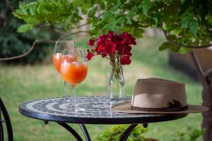 a table with two glasses and a hat and flowers at Olivos de Terrada in Ciudad Lujan de Cuyo