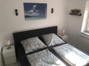 1 dormitorio con 1 cama con 2 almohadas en Dachgeschosswohnung-15min vom Europa Park entfernt, en Kenzingen