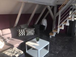 uma sala de estar com um sofá e uma escada em Dachgeschosswohnung-15min vom Europa Park entfernt em Kenzingen
