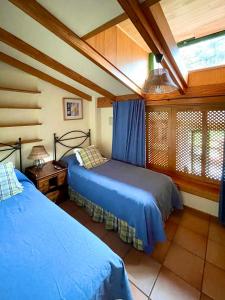 a bedroom with two beds and a window in it at Casa Rural en medio del bosque, El Lance in Firgas