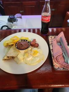 a white plate of food with eggs and bacon on a table at Roatan Yacht Club and Dive Center in Roatán