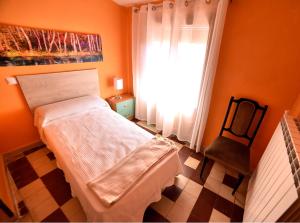 ein kleines Schlafzimmer mit einem Bett und einem Fenster in der Unterkunft Posada-18 in Malón