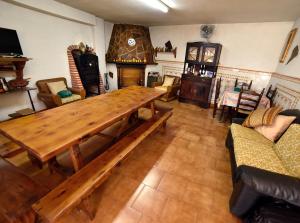 ein Wohnzimmer mit einem Holztisch und einem Kamin in der Unterkunft Posada-18 in Malón