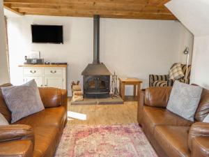 uma sala de estar com um sofá e uma lareira em Dragon Hill Barn em Matlock