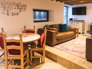 uma sala de estar com uma mesa e um sofá em Dragon Hill Barn em Matlock