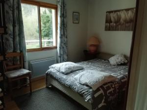 a bedroom with a bed and a window at La maison au bord de l'eau in Plouigneau
