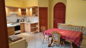 a kitchen with a table and a table and chairs at Abigel Thermal Apartman in Bük