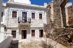 an old stone building with a balcony on it at Platsa's House in Apérathos