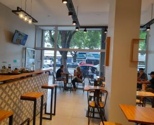 a restaurant with tables and people sitting at tables at Casa Be Suites in Rosario