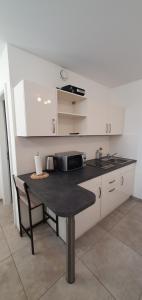 a small kitchen with a table and a sink at Pearl Studio Apart - King Bed - Netflix - Projector - Fast Wi-Fi in Trier