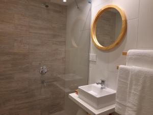 a bathroom with a sink and a mirror at Casa Be Suites in Rosario