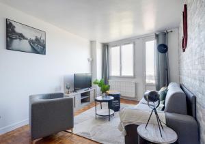 a living room with a couch and a tv at Le PRIVILEGE aux PORTES de PARIS in Bagnolet