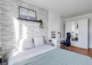 a bedroom with a bed and a brick wall at Le PRIVILEGE aux PORTES de PARIS in Bagnolet