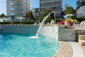 a water fountain in a swimming pool in a building at Hotel Luxor in Milano Marittima