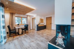 een woonkamer met een open haard en een tafel en stoelen bij Apartklusiv Kaltenbach in Kaltenbach