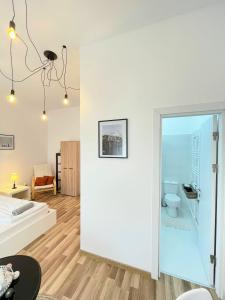 a white room with a bed and a toilet at Apartament Plopilor Studios in Sibiu
