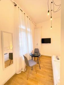 a room with a table and a chair and a mirror at Apartament Plopilor Studios in Sibiu