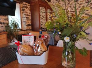 un jarrón de flores y una cesta de pan sobre una mesa en Haraneko errota, en Chávarri