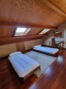 a attic room with two beds and a table at Apartamentos Turísticos Betanzos in Betanzos