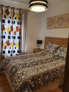 1 dormitorio con cama con edredón y ventana en CAMPANUCA, en Unquera