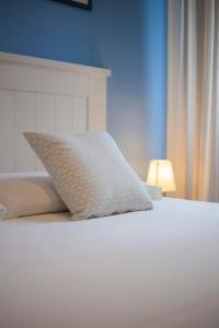 a white pillow sitting on top of a bed at La Petite Maison in Portoferraio