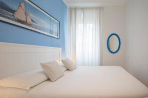 a white bed with two pillows on top of it at La Petite Maison in Portoferraio