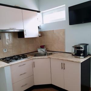 a kitchen with white cabinets and a sink at Apartament Deja Vu-Bieszczady in Ustrzyki Dolne
