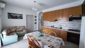 a kitchen with a table and a couch in a room at Uliveto in Diano San Pietro