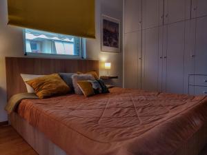 a bedroom with a large bed with orange sheets and pillows at Euphoria Apartment in Nafplio