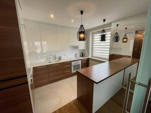 kuchnia z drewnianymi szafkami i blatem w obiekcie ESEN Apartamenty Krakowska w mieście Białystok