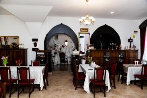 a dining room with tables and chairs and a chandelier at VILA Corviniana in Hunedoara