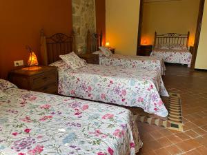 a bedroom with three beds with pink and white sheets at Casa Cundaro in Girona