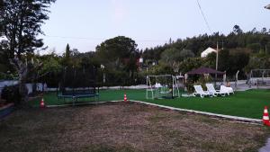 a park with a playground with chairs and swings at Visitar Bioucas II - Casa Tradicional Familiar in Bioucas
