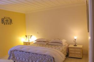 a bedroom with a bed and a lamp at Pousada Casa Gialla in Campos do Jordão
