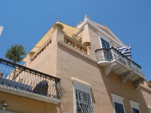 a building with a balcony on top of it at Arhontiko Ermoupolis in Ermoupoli