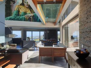 una sala de estar con una gran pintura de una mujer en Luxury Home located on Pinnacle Point Golf Estate, en Mossel Bay
