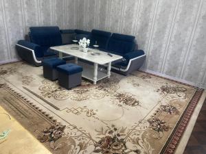 un soggiorno con un divano blu e un tavolo di Cozy apartment a Samarkand