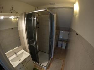 W łazience znajduje się prysznic i umywalka. w obiekcie Pokoje u Ani w mieście Srokowo