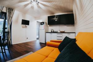 sala de estar con sofá naranja y cocina en Wellness Resort Szécseny, en Jögödfürdő
