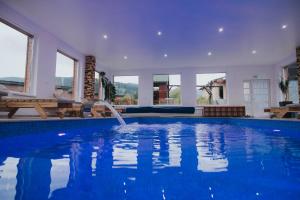 una piscina con una fuente en una casa en Wellness Resort Szécseny, en Jögödfürdő