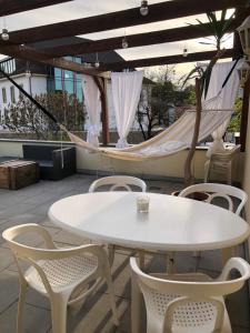- une table et des chaises sur une terrasse avec un hamac dans l'établissement Ferienwohnung Sonne, à Schliengen