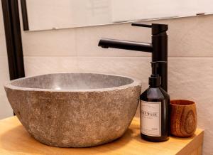 eine Flasche Wein neben einem Waschbecken in der Unterkunft Almara - Family Apartment in Bad Goisern