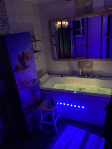 a bathroom with a tub with a table next to it at Au pont des Charettes - Villa piscine et SPA in Uzès