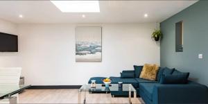 a living room with a blue couch and a table at Little Seven Oaks in Langley