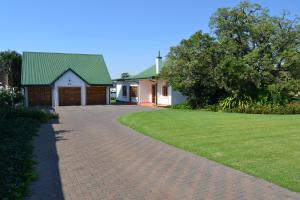 una casa con techo verde y entrada de ladrillo en Lekkerrus guesthouse, en Krugersdorp