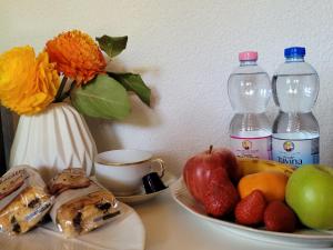 a table with a plate of fruit and two bottles of water at Villa Castagna Guesthouse in Lucerne