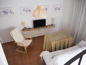 sala de estar con sofá, mesa y TV en Sendero de la Subbetica - Apartamentos Turisticos en Zuheros - Holiday Home, en Zuheros